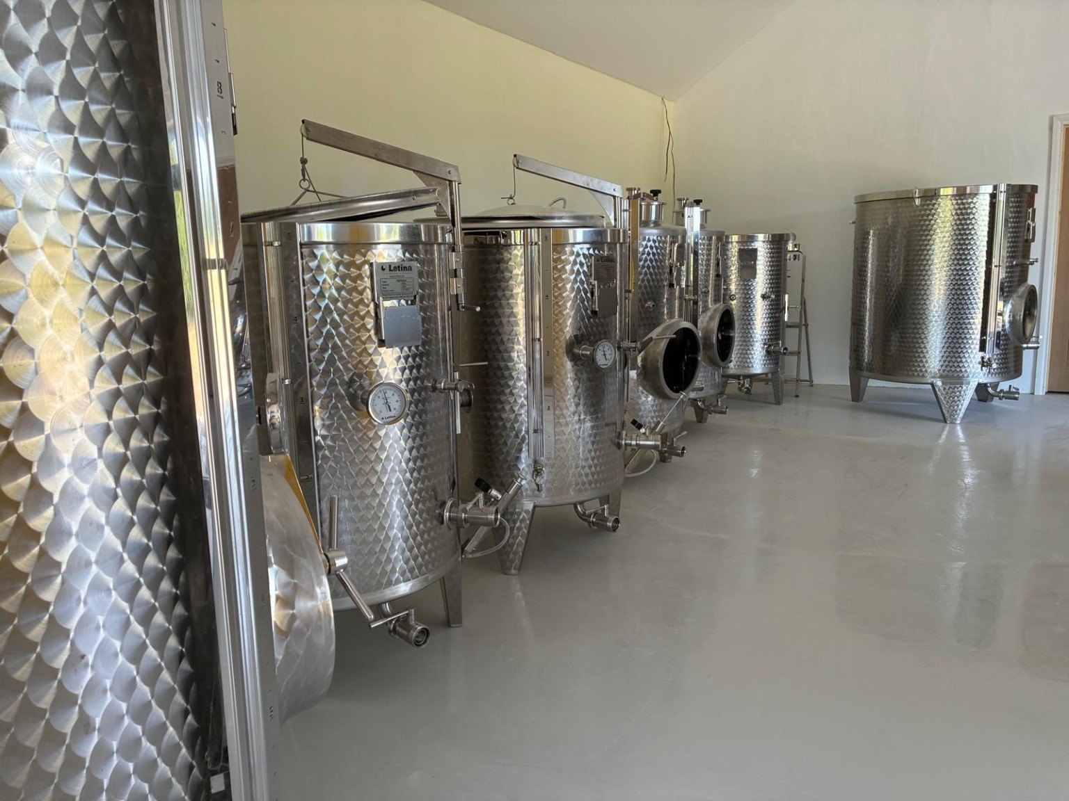 Stainless-steel winemaking tanks in a cellar
